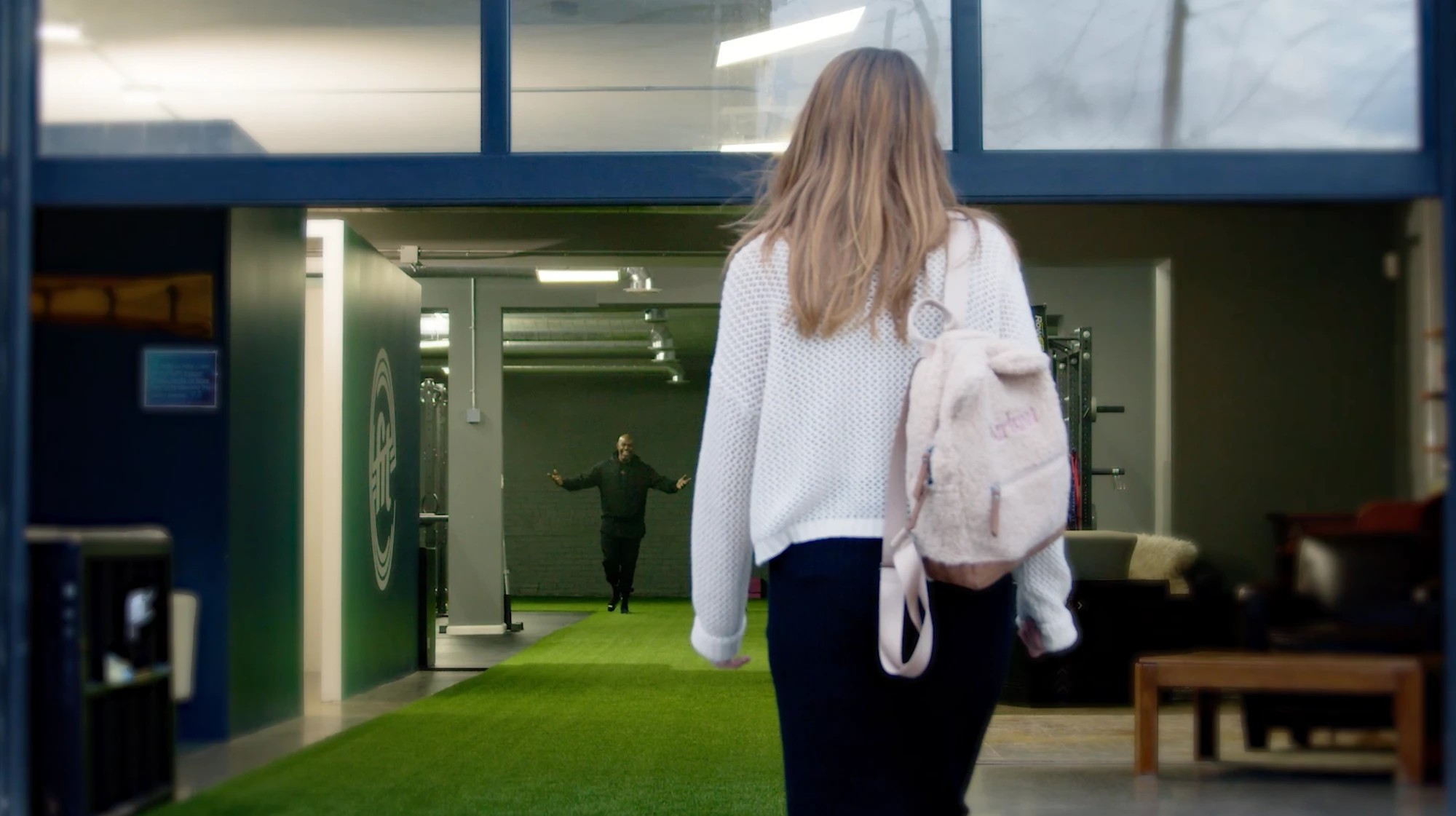 A member arriving at eFIT's facility, greeted warmly by a staff member