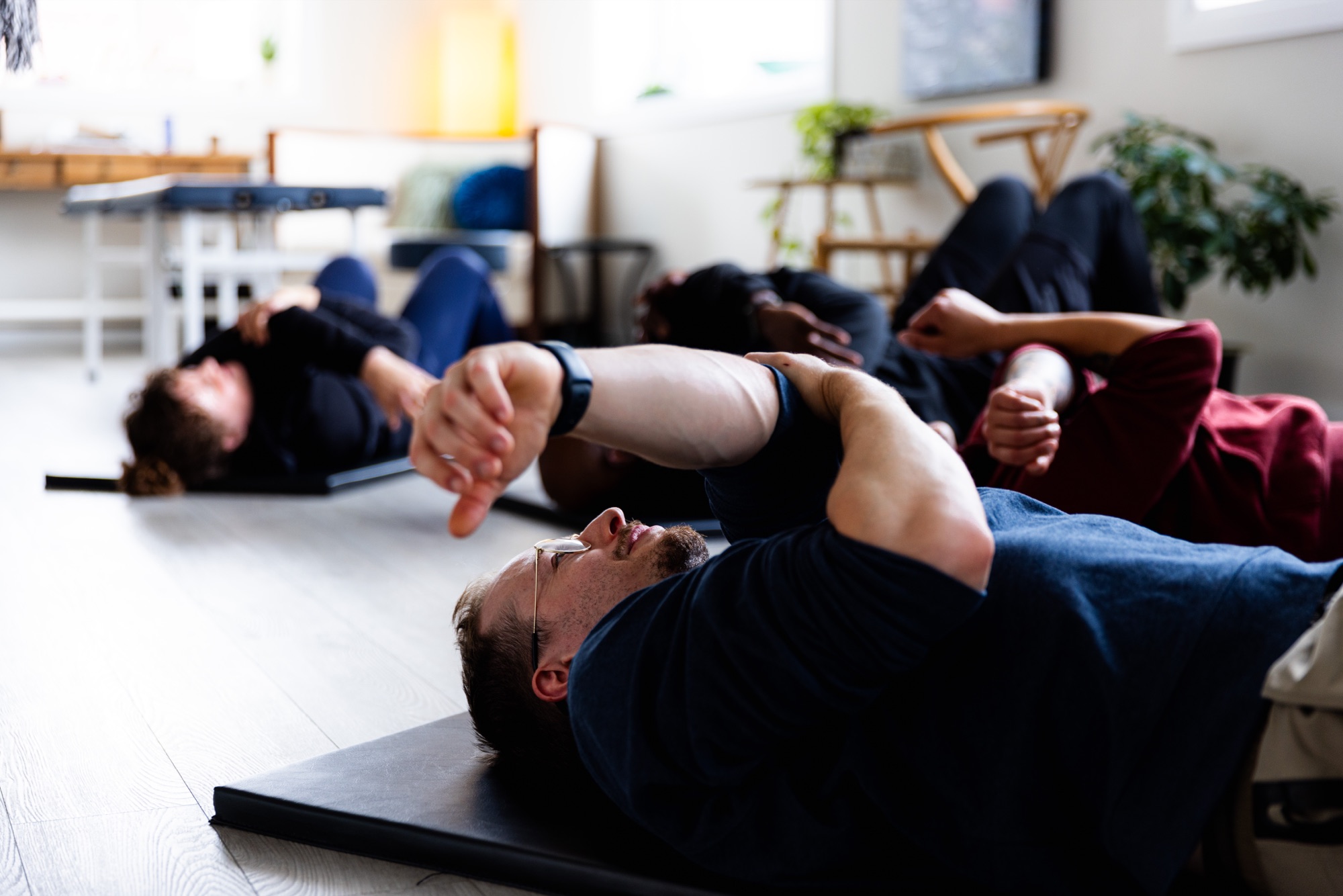 Members lying on mats during a gentle somatic floor practice