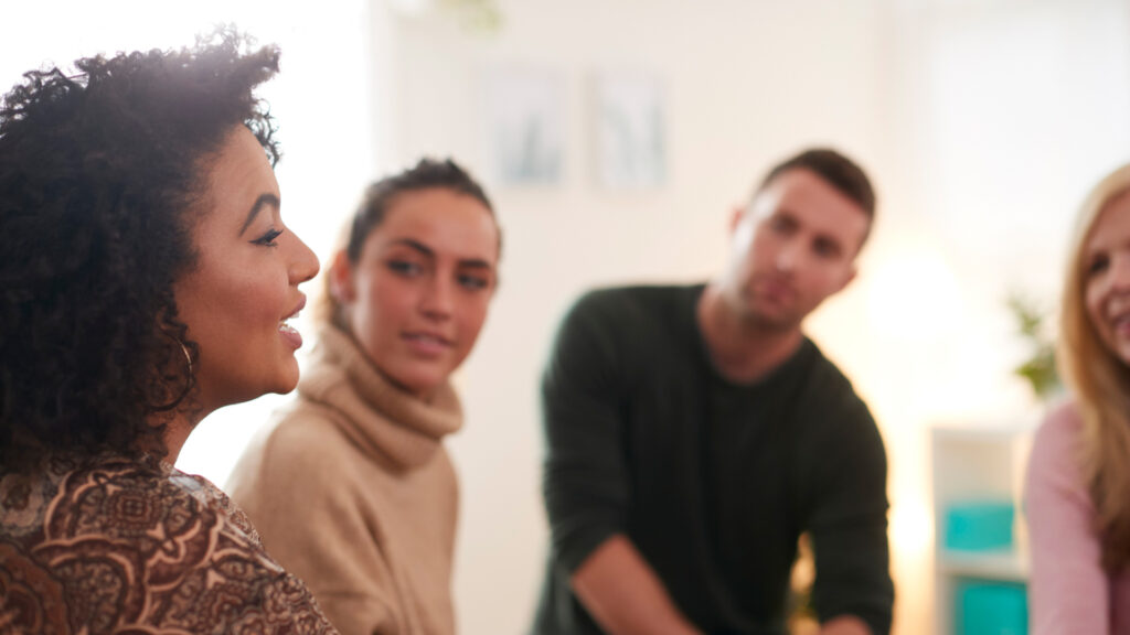 Four people sitting in a group therapy session